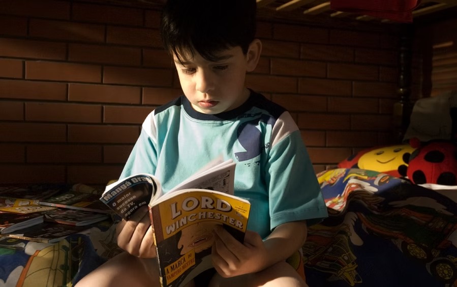 Menino com uma lanterna, em um ambiente de suspense.